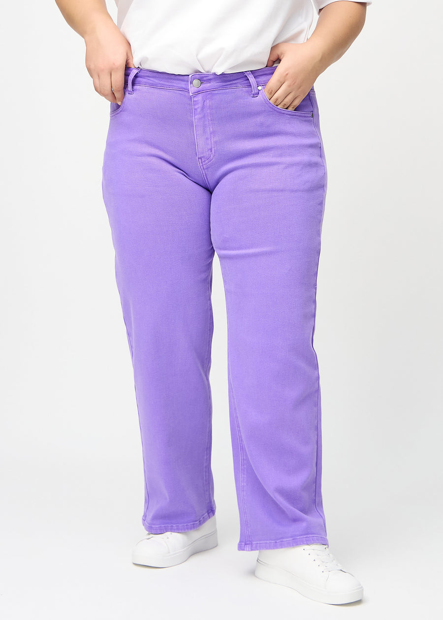 Lilla loose jeans, modelnavn Lavenders, som er løstsiddende med masser af vidde i benene på en plus-size model, set forfra.