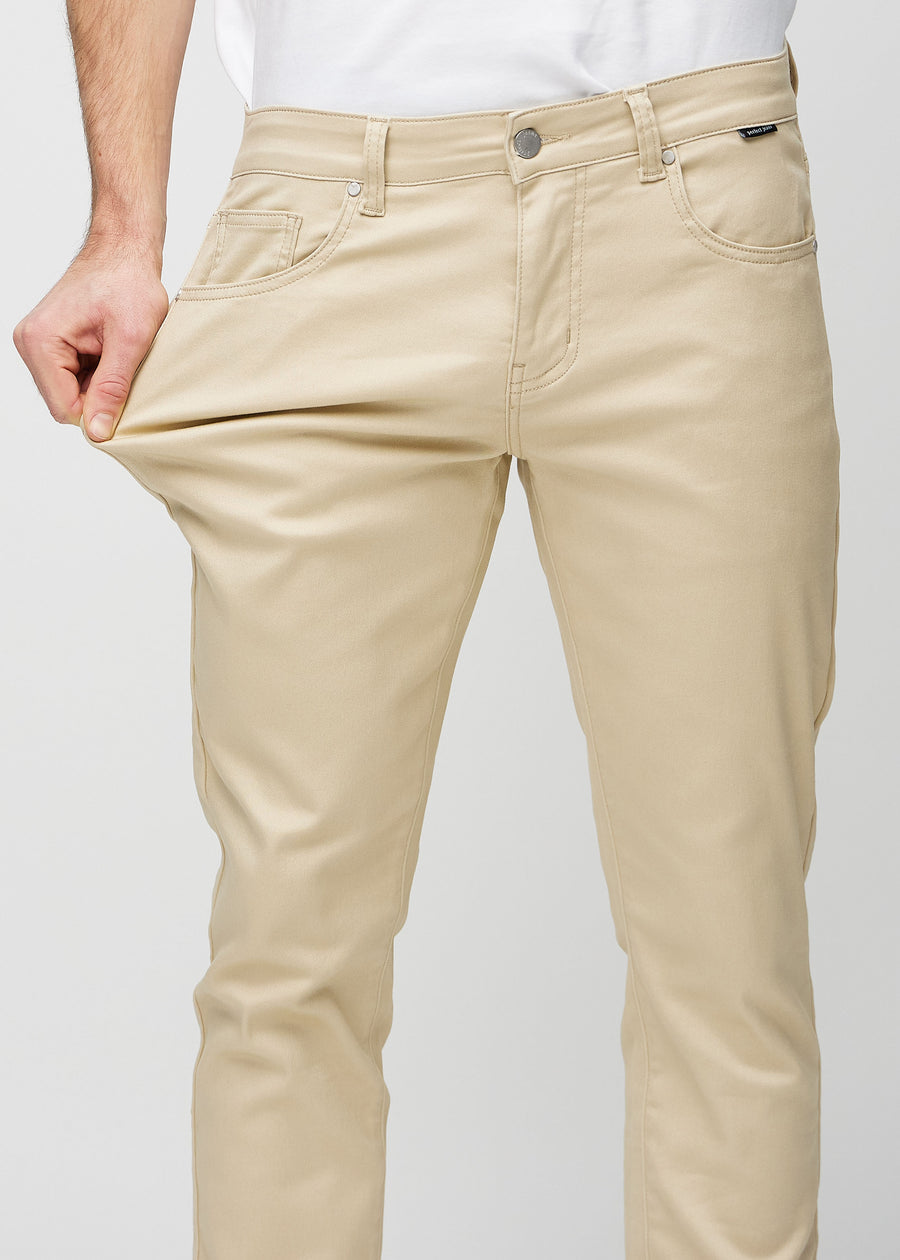 Model strækker jeansene ved låret for at vise stretch.