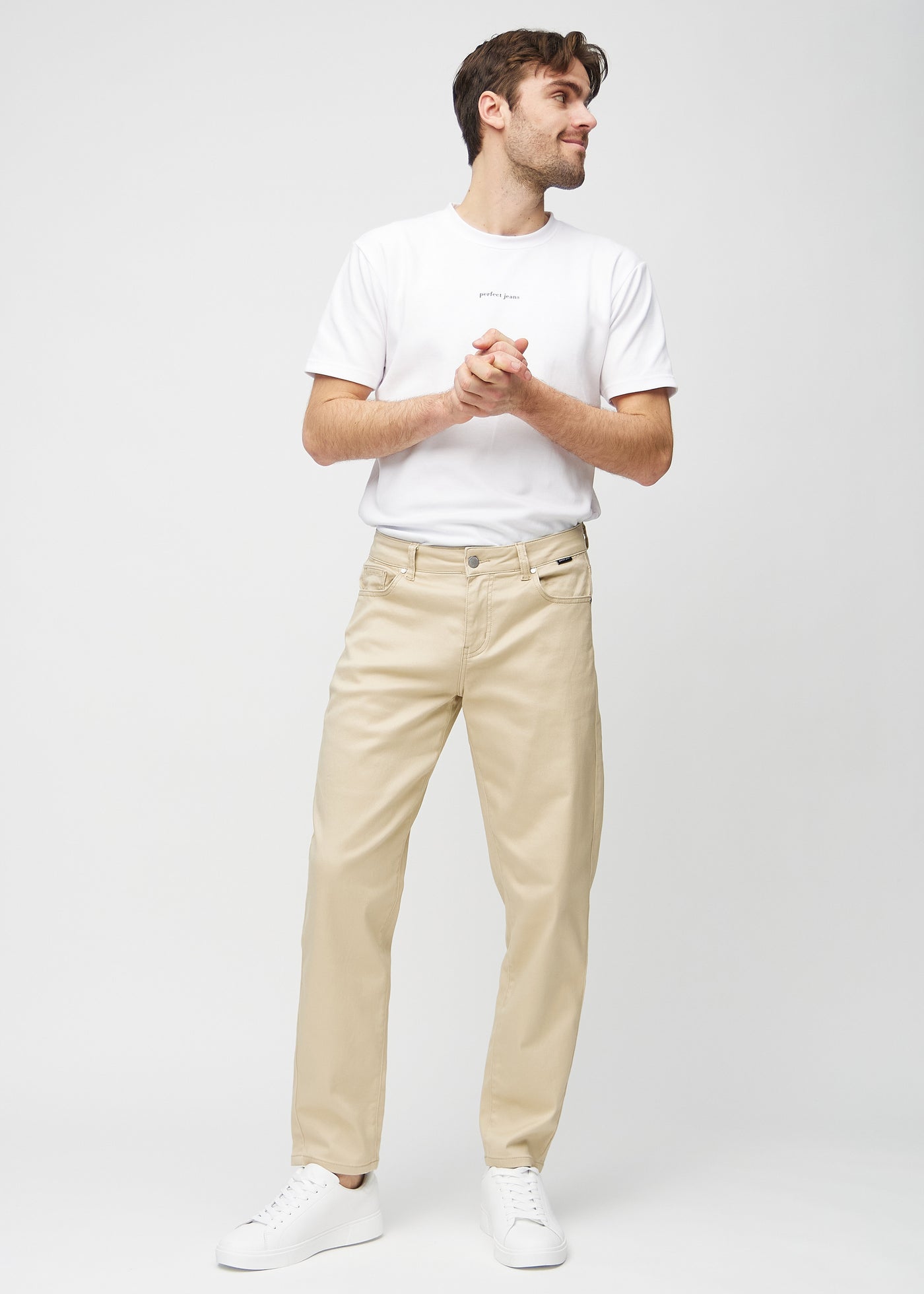 Fuldt billede af model i beige regular jeans.