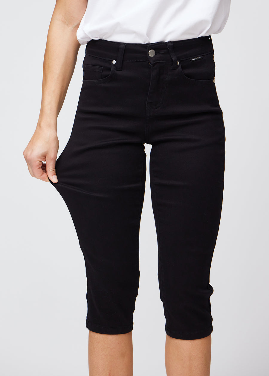 Model strækker caprisene ved låret for at vise det bløde og fleksible stretch.