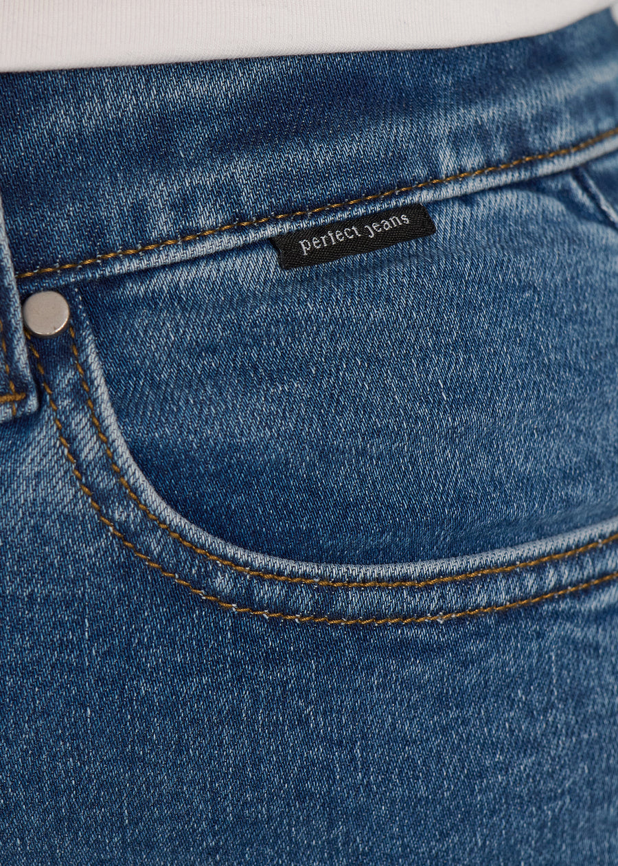 Forlommen på et par blå denim jeans, hvor man kan se logoet. på en plus-size model.