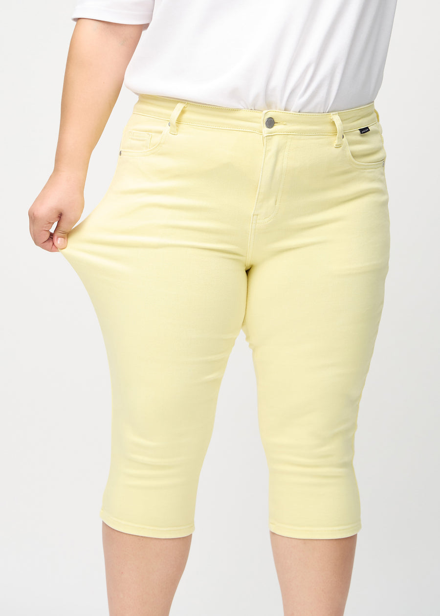 Plus-size model strækker caprisene ved låret for at vise stretch.