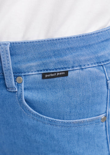 Nærbillede af blåt jeansmateriale med Perfect Jeans logoetiket ved forlommekanten.