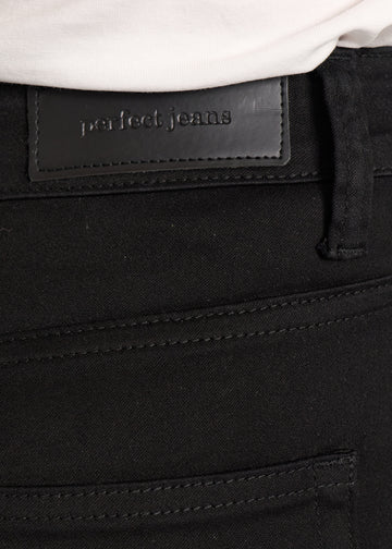 Nærbillede af sort jeansmateriale med Perfect Jeans læderpatch bagpå i taljen.