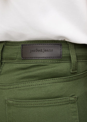 Nærbillede af grønt jeansmateriale med Perfect Jeans læderpatch bagpå i taljen.