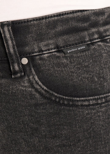 Nærbillede af mørkegrå denim med Perfect Jeans logoetiket ved forlommekanten, på en plus-size model.