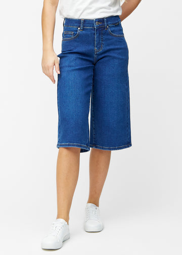Løse, mørkeblå denim capris i farven Oceans, der sidder til ved hoften og falder løst ned over lårene til lige under knæet, set forfra.