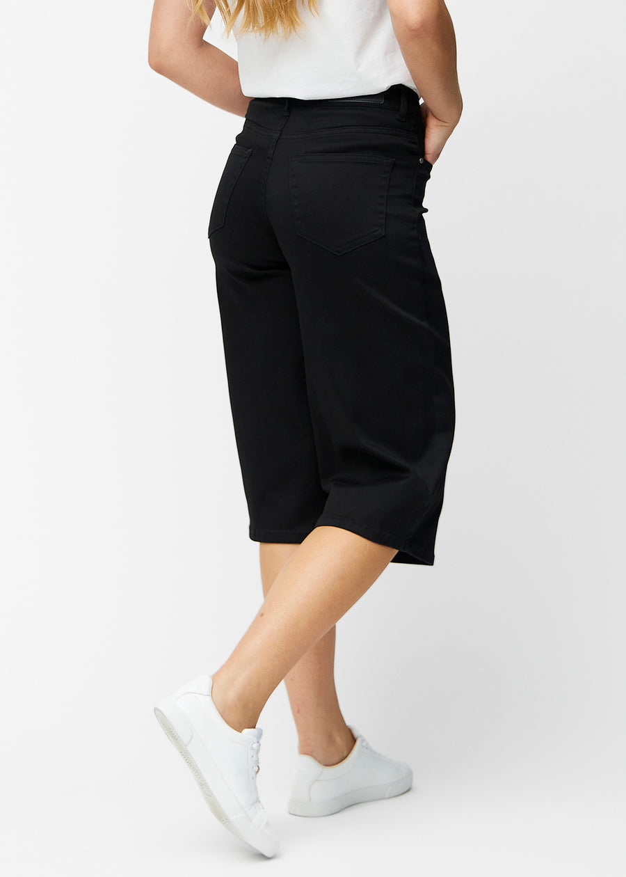 Løse, sorte capris i farven Ravens set bagfra, så pasform og længde kan ses.