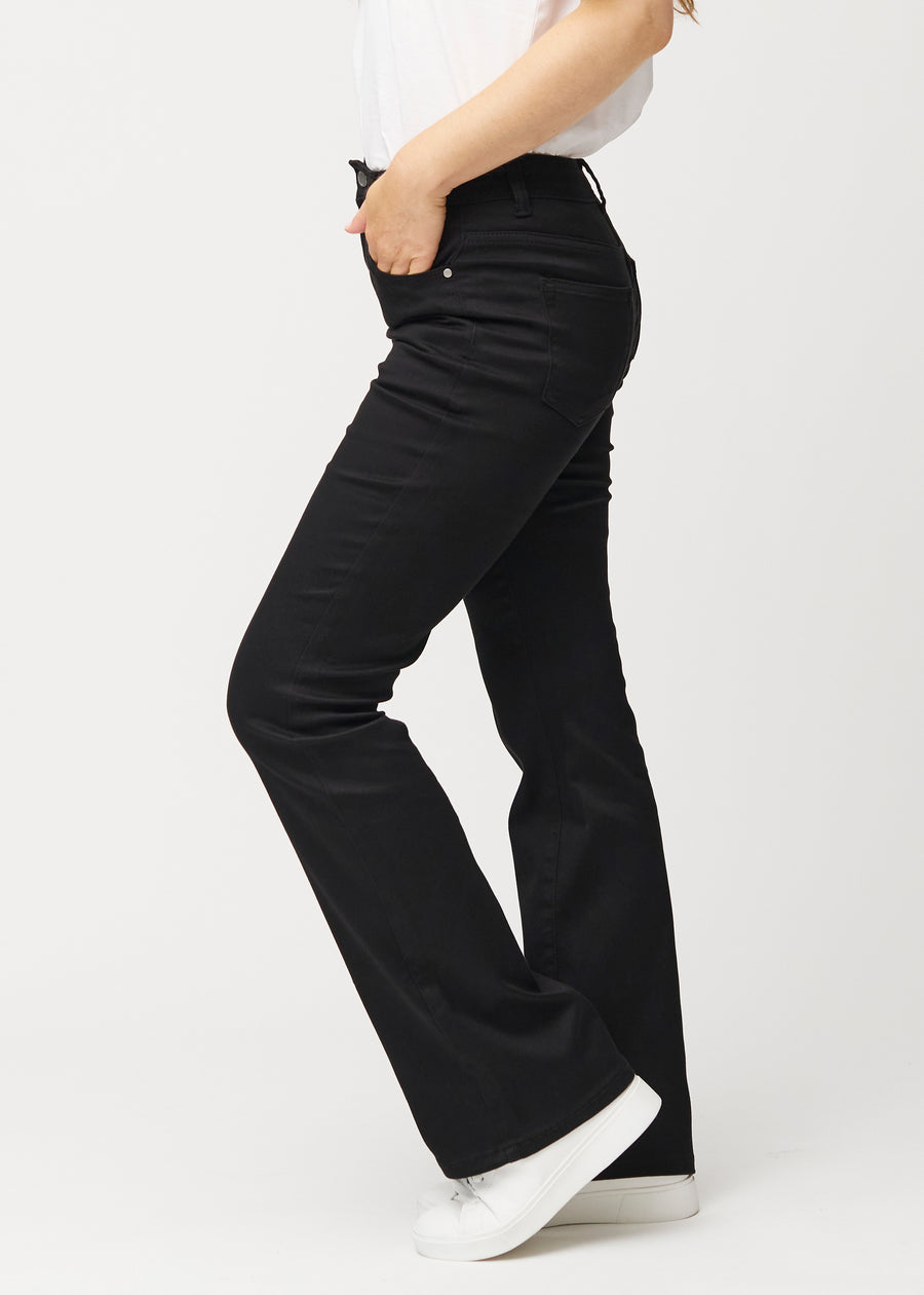 Black mid-rise bootcut jeans in Ravens. Side view on a model.