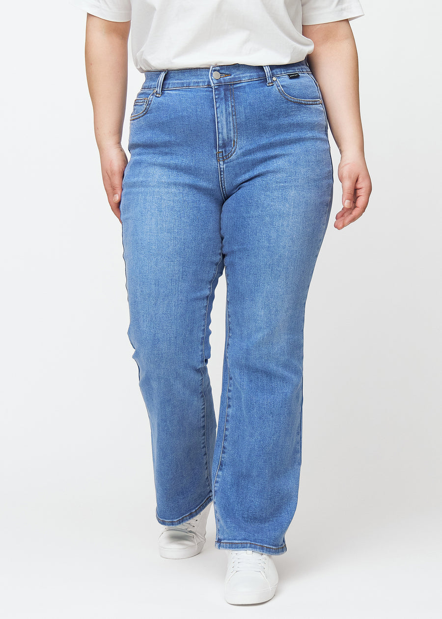 Blue mid-rise bootcut jeans in Rivers. Front view on a plus-size model, fitted through the hips and thighs with a gentle flare at the hem.