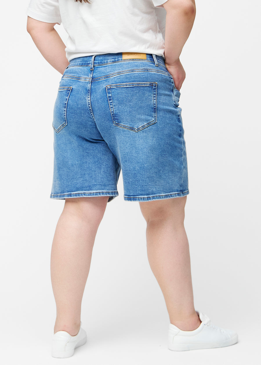 Løse, klassisk blå denim shorts i farven Rivers set bagfra på plus-size model, så pasform og længde kan ses.