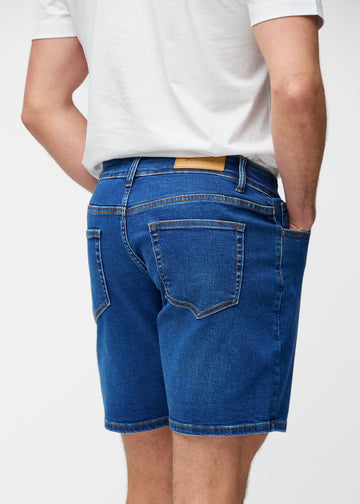 Dark blue denim shorts for men in the colour Oceans seen from the back close up to show fit and details.