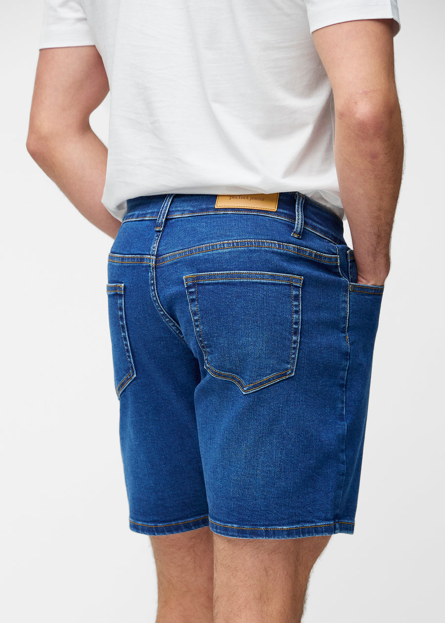 Dark blue denim shorts for men in the colour Oceans seen from the back close up to show fit and details.