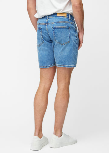 Blue denim shorts for men in the colour Rivers seen from the back, showing the length just above the knee and the fit.