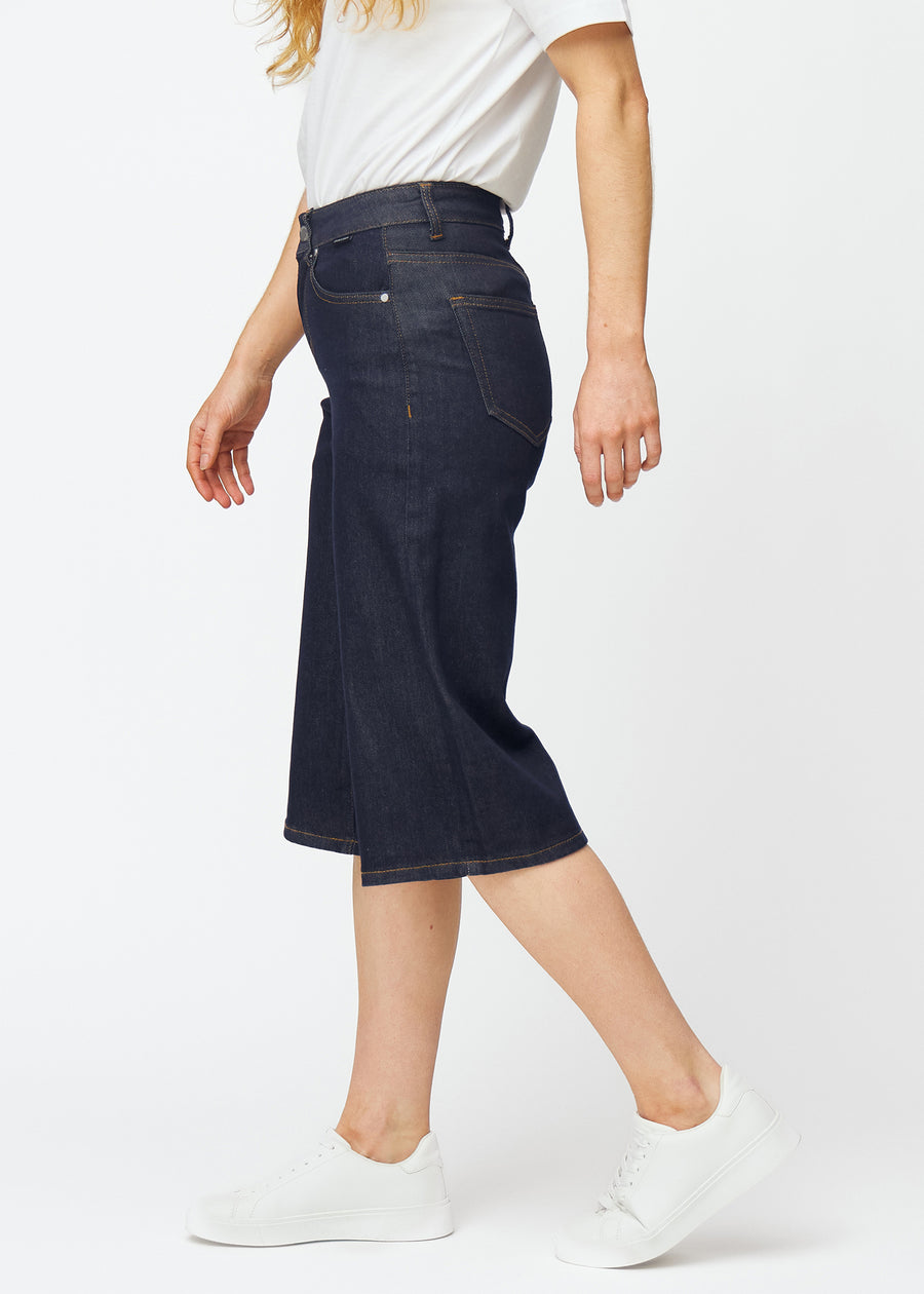 Deep dark blue denim capris for women in the colour Midnights with a loose fit seen from the side on a model.