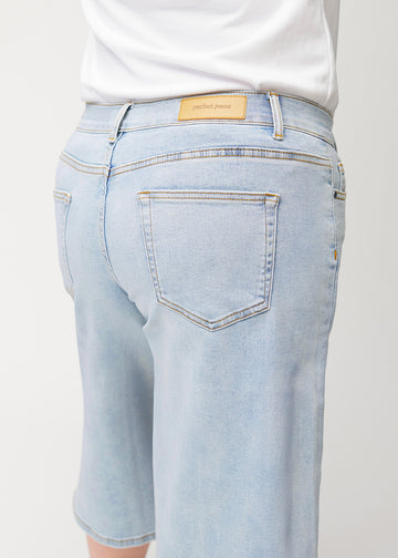 Løse, lyseblå denim capris i farven Waves set bagfra tæt på på plus-size model for at vise pasform og detaljer.