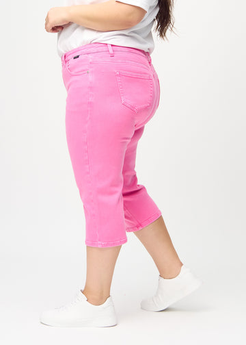 Light pink regular capris seen from the side on a plus-size model.