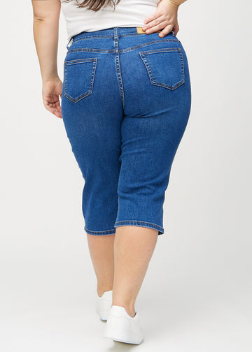 Dark denim regular capris seen from the back on a plus-size model, so you can see the entire product.