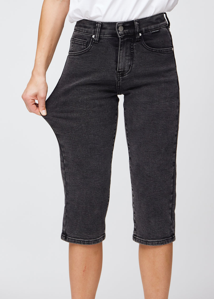 The model stretches the capris at the thigh to show the stretch.
