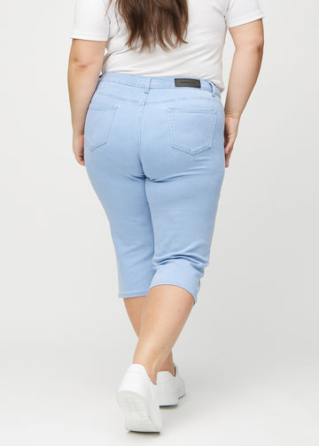 Light blue regular capris seen from the back on a plus-size model, so the full product can be seen.