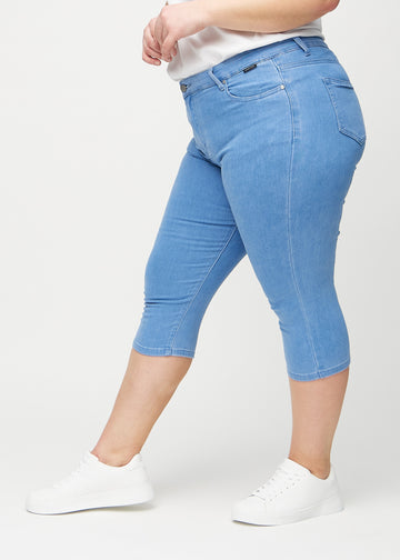 Skinny capris for women in blue fabric, color Geraniums. Side view on a plus-size model, showing the fitted cut.