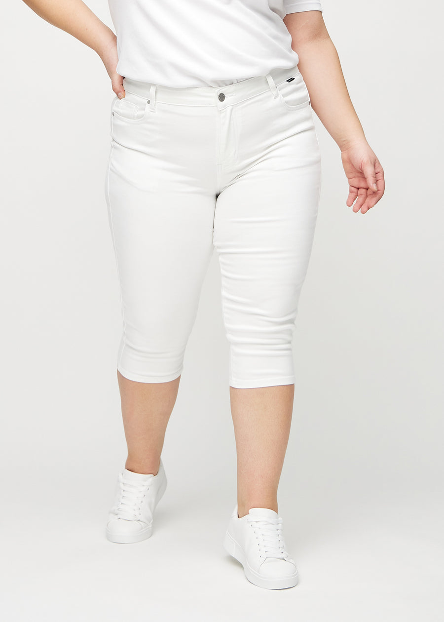 Skinny capris for women in white fabric, color Marguerites. Front view on a plus-size model, showing the close-fitting legs ending just below the knee.