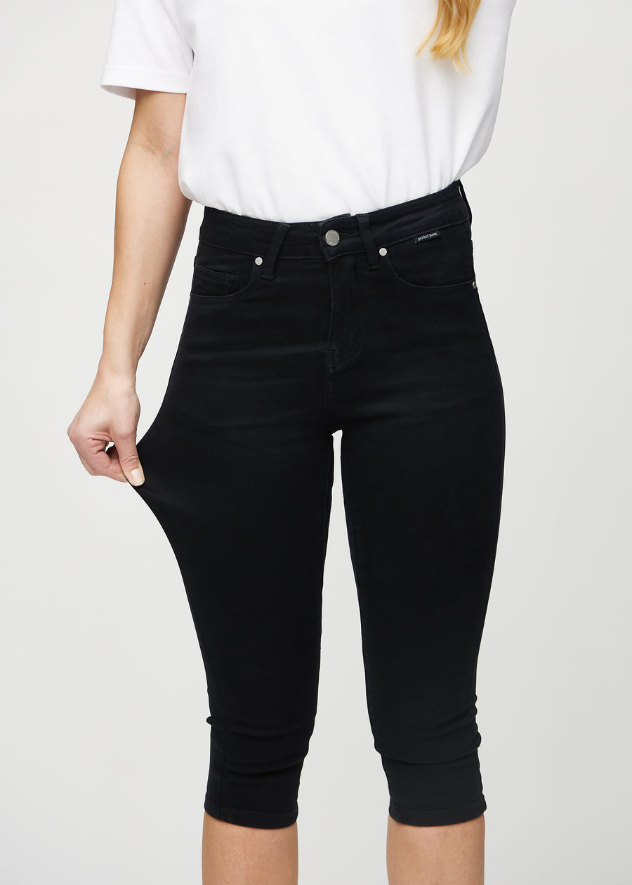The model stretches the capris at the thigh to show the stretch.