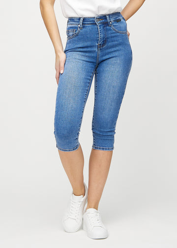 Skinny capris for women in blue denim, color Rivers. Front view on a model, showing the close-fitting legs ending just below the knee.