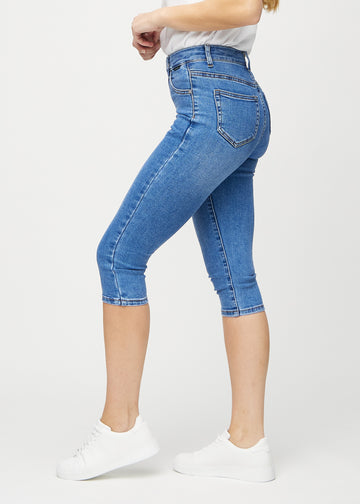 Skinny capris for women in blue denim, color Rivers. Side view on a model, showing the fitted cut.