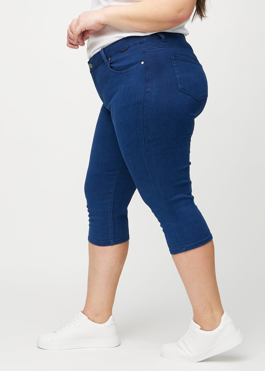 Skinny capris for women in dark blue fabric, color Royals. Side view on a plus-size model, showing the fitted cut.