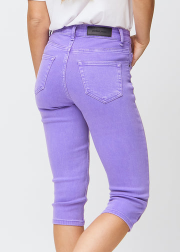 Slim capris for women in pastel purple jeans fabric, color Lavenders. Close-up from behind on a model, highlighting the back pockets and stitching.