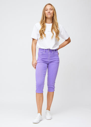 Slim capris for women in pastel purple jeans fabric, color Lavenders. Full-length view of a model wearing slim capris.