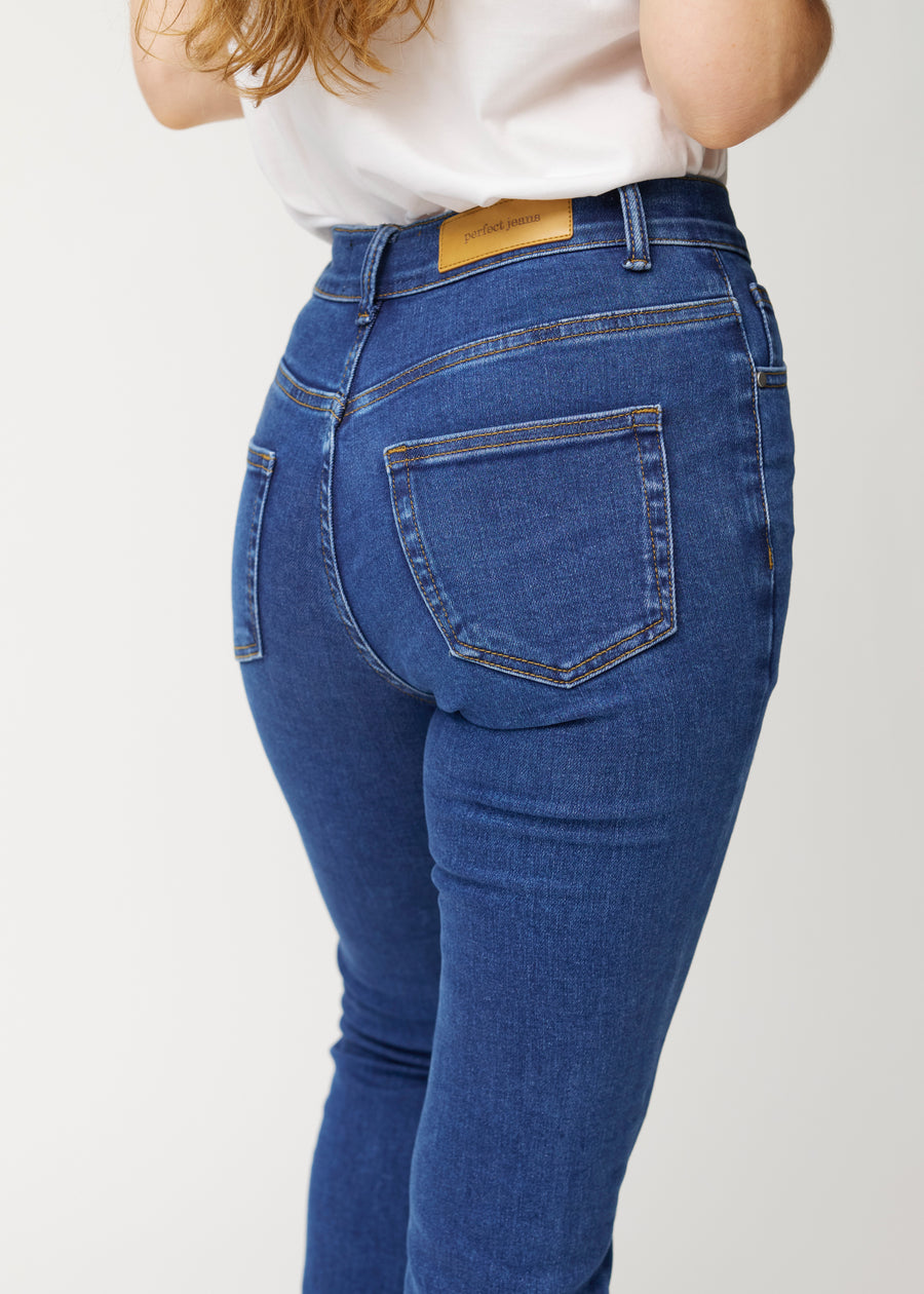 Dark blue mid-rise bootcut jeans in Oceans. Close-up back view on a model, showing the details.