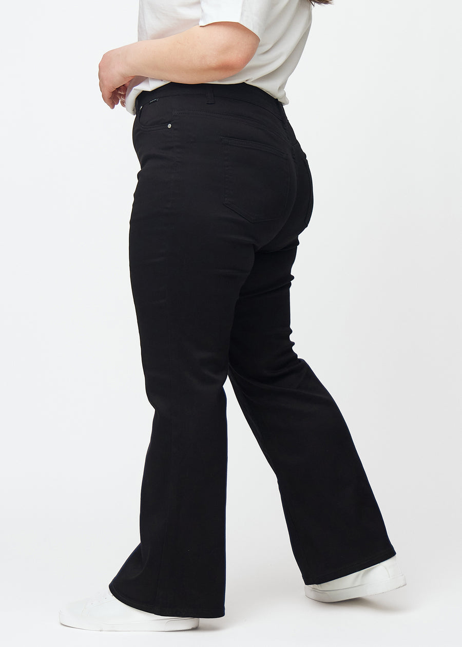 Black mid-rise bootcut jeans in Ravens. Side view on a plus-size model.