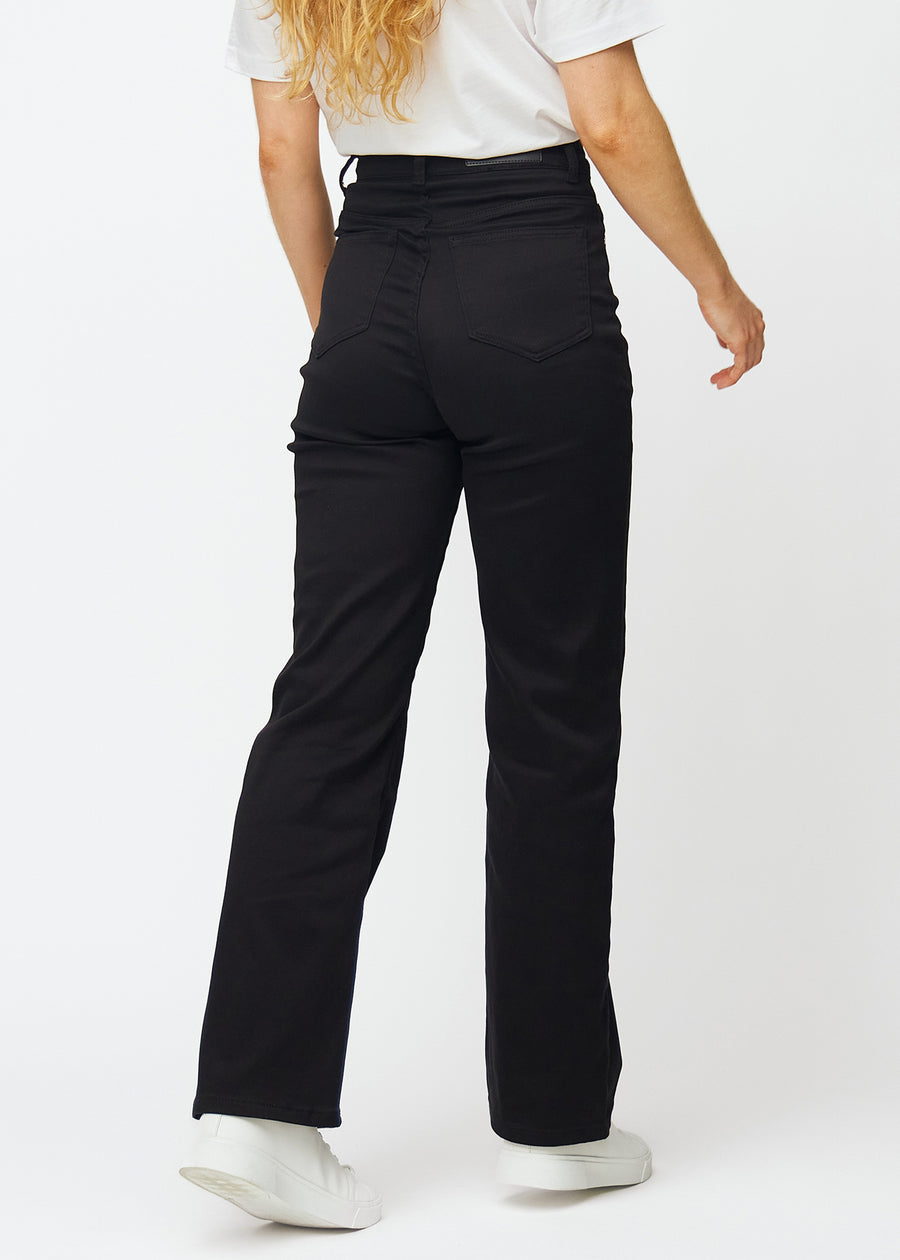 Black high-waisted jeans, which are fitted at the waist and have a loose fit with width down the leg, shown from the back to show the full product.