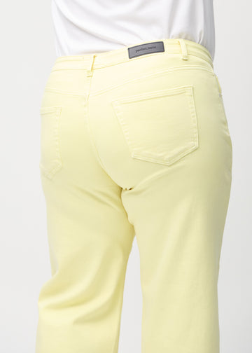 Loose jeans for women in light yellow, color Lemonades. Close-up from behind on a plus-size model, showing the fit and details.