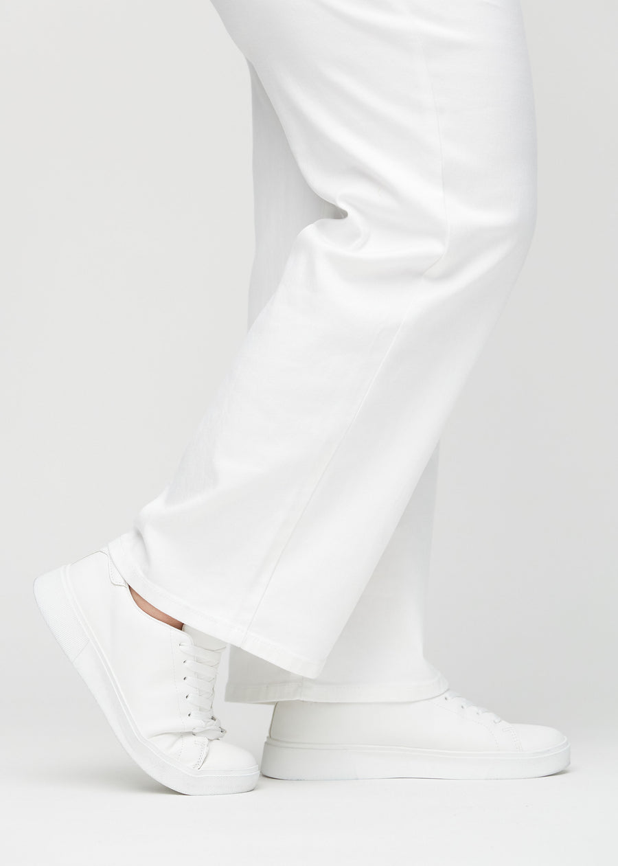 Loose jeans for women in white, color Marguerites. Close-up at the ankles on a plus-size model, showing the wide leg openings.