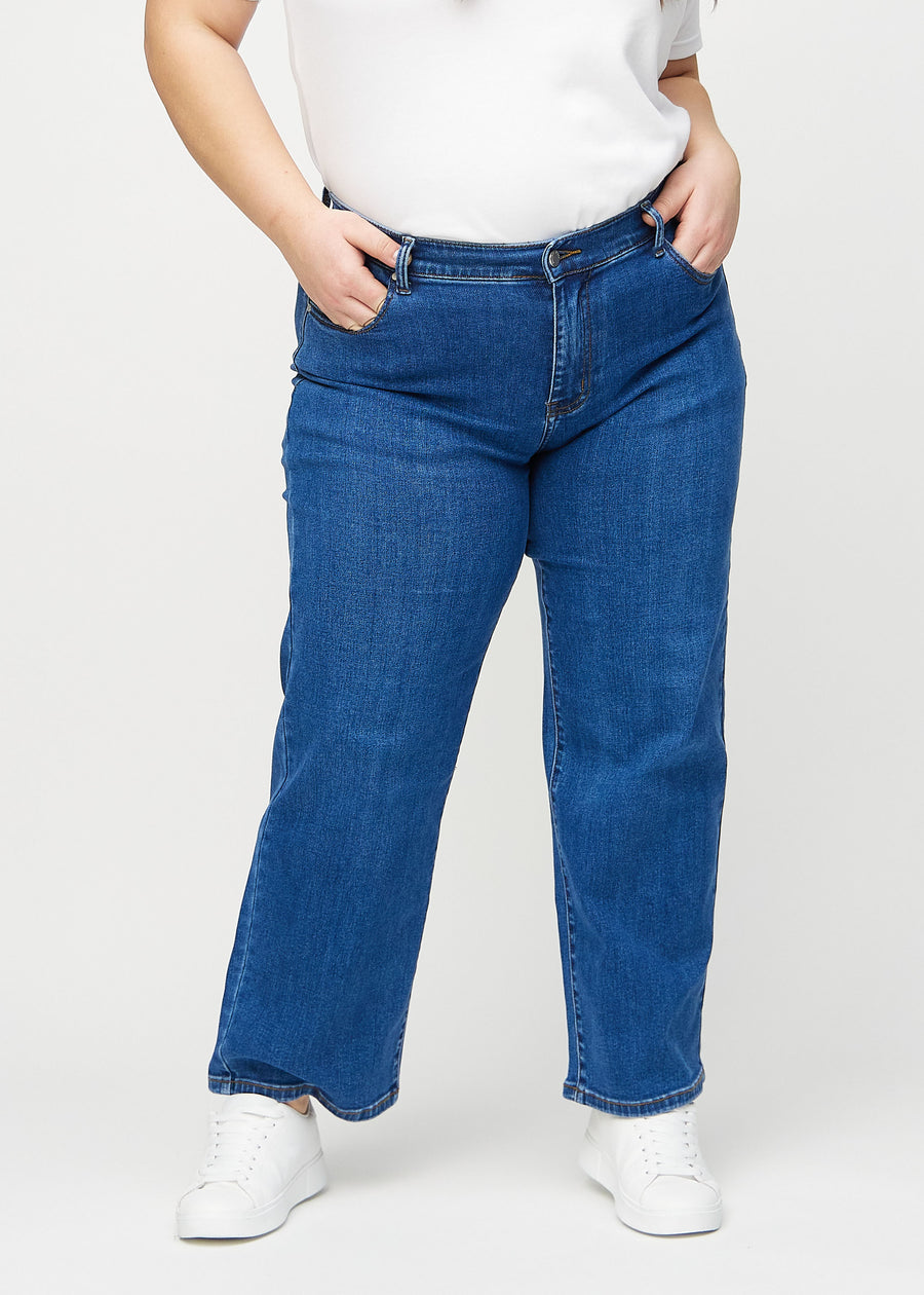 Loose jeans for women in dark blue, color Oceans. Front view on a plus-size model, showing the roomy, wide-leg fit.