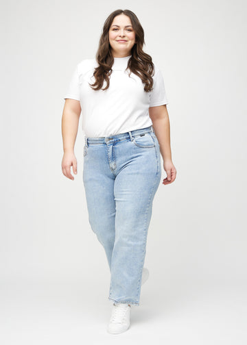 Full image of a plus-size model in light denim loose jeans.