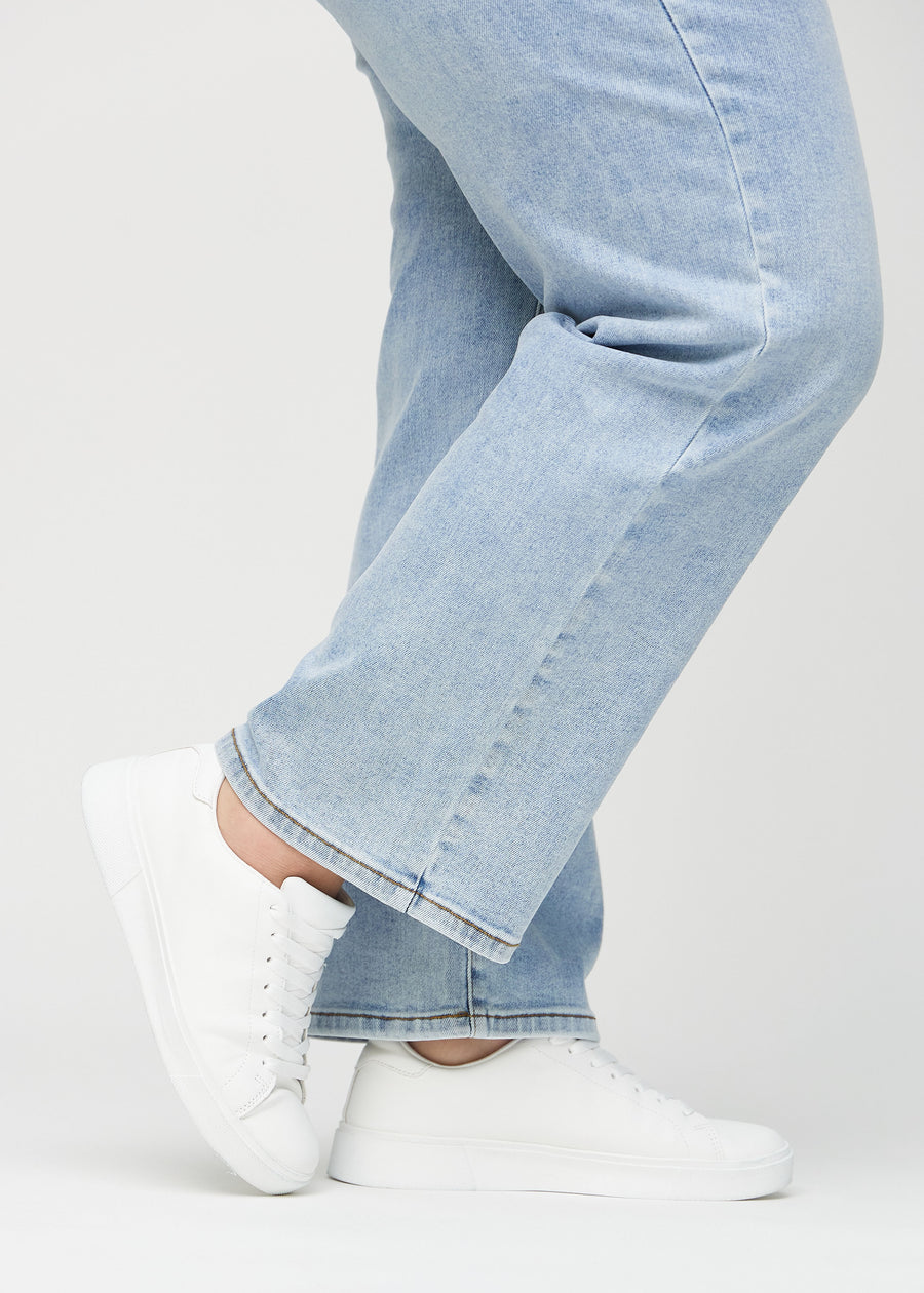 The ankles of a plus-size model, so you can see how loose the jeans fit.