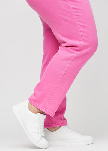 Regular jeans for women in light pink, color Flamingos. Close-up at the ankles on a plus-size model, showing the straight leg openings.
