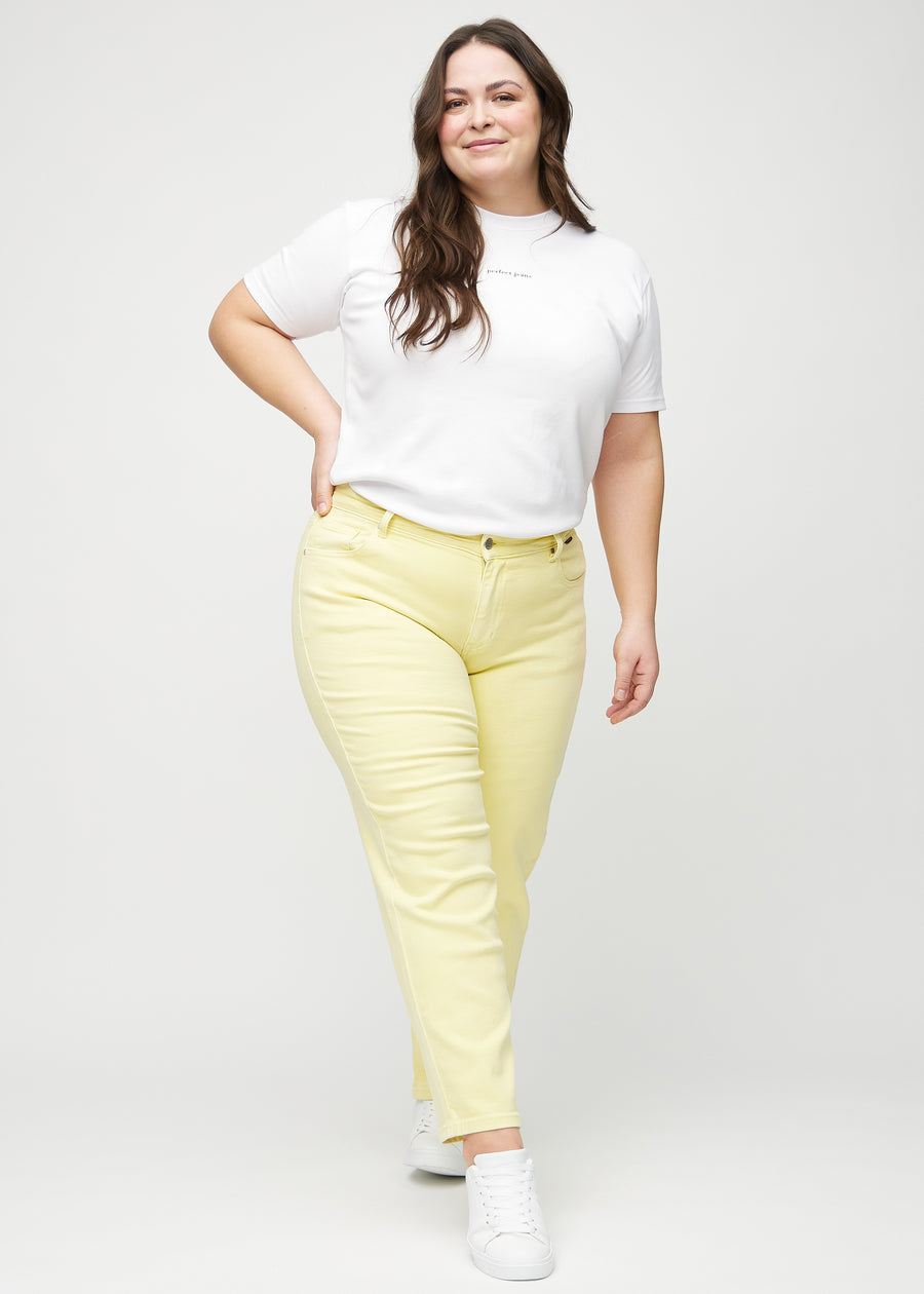 Regular jeans for women in light yellow, color Lemonades. Full-length view of a plus-size model wearing the jeans.