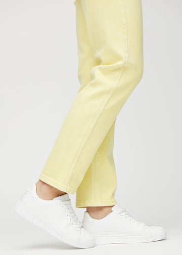 Regular jeans for women in light yellow, color Lemonades. Close-up at the ankles on a model, showing the straight leg openings.