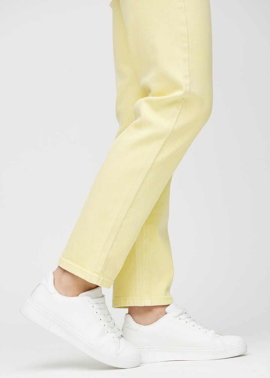 Regular jeans for women in light yellow, color Lemonades. Close-up at the ankles on a model, showing the straight leg openings.