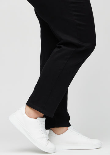 The ankles of a plus-size model, so you can see how loose the jeans fit in a Regular fit.