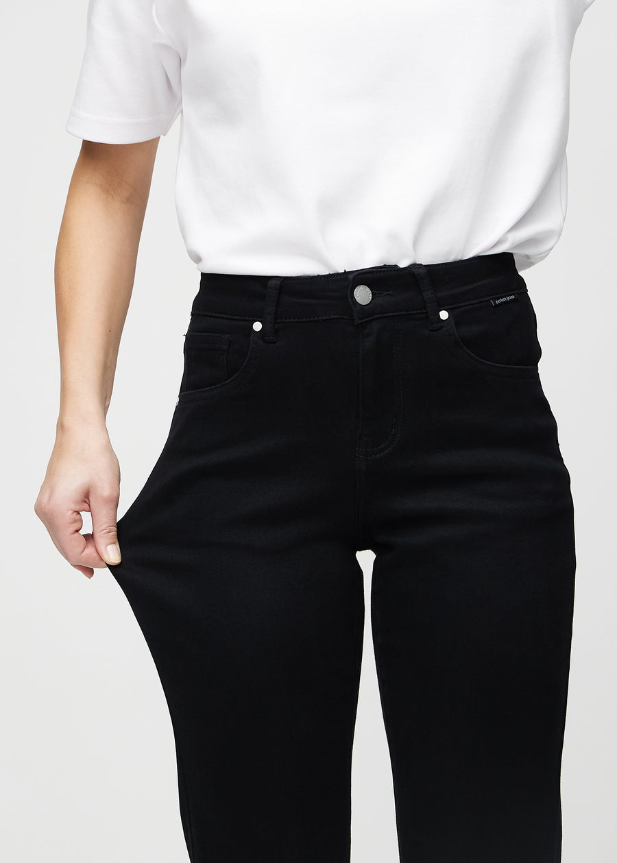 The model stretches the jeans at the thigh to show the stretch.
