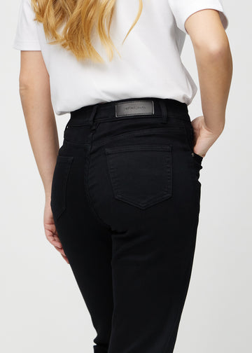 Black regular jeans seen from the back close up to show details.