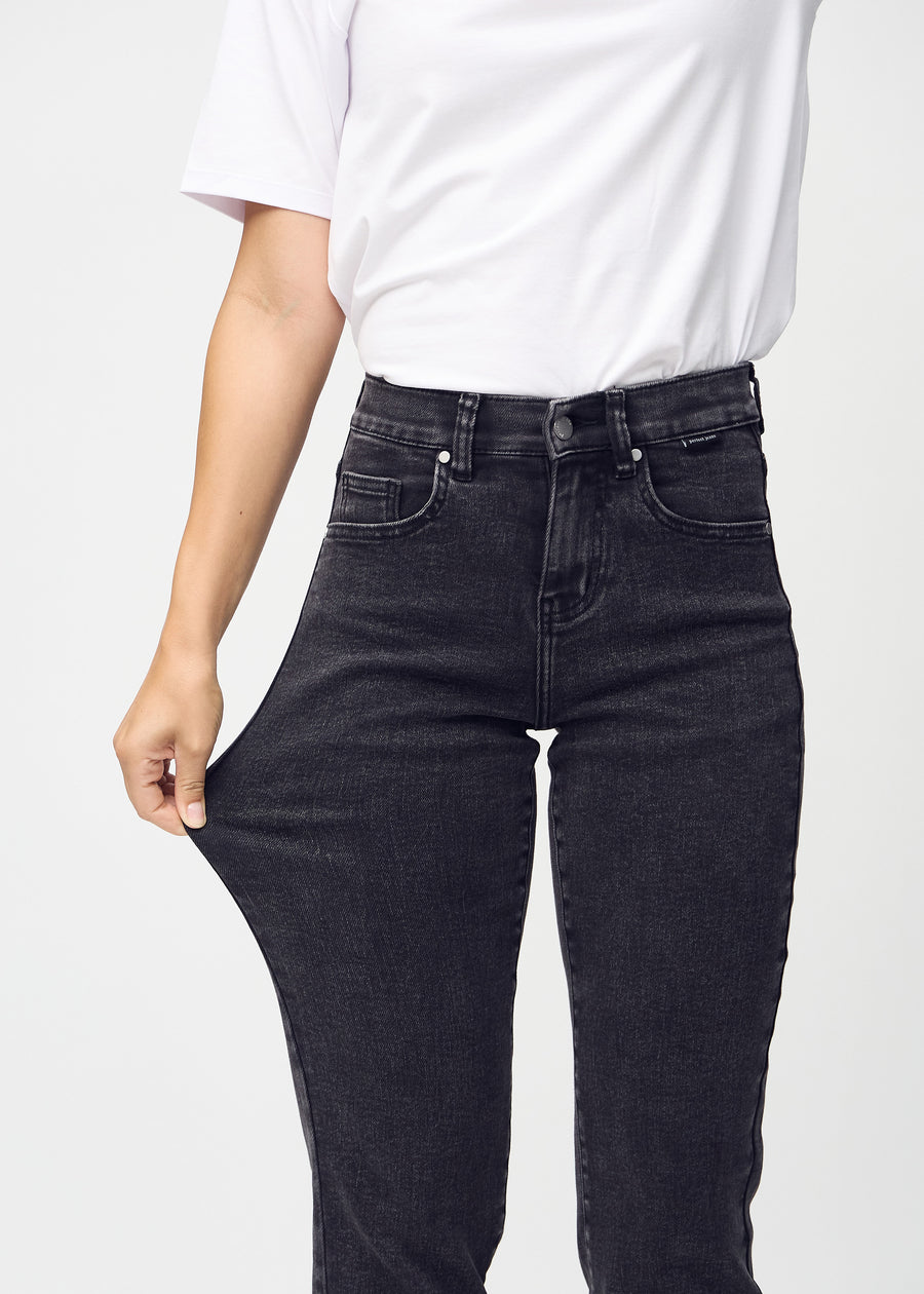 Regular jeans for women in dark grey, color Shadows. A model stretches the fabric at the thigh to show its stretch.