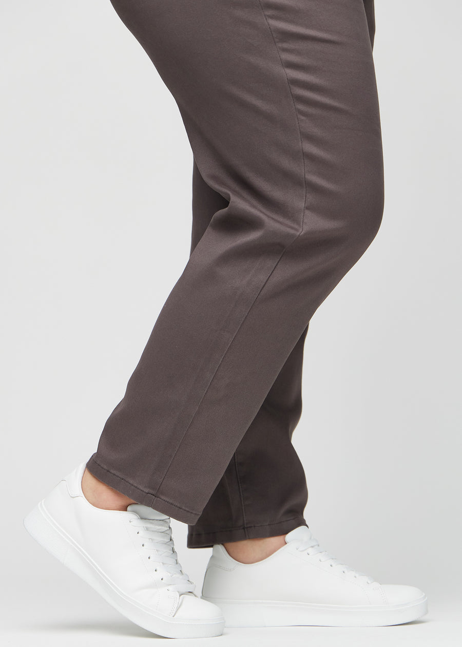 Regular jeans for women in grey-brown, color Thunders. Close-up at the ankles on a plus-size model, showing the straight leg openings.