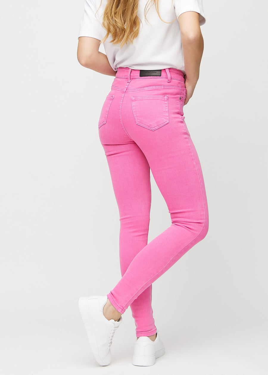 Skinny jeans for women in light pink, color Flamingos. Back view on a model, showing the full fit.